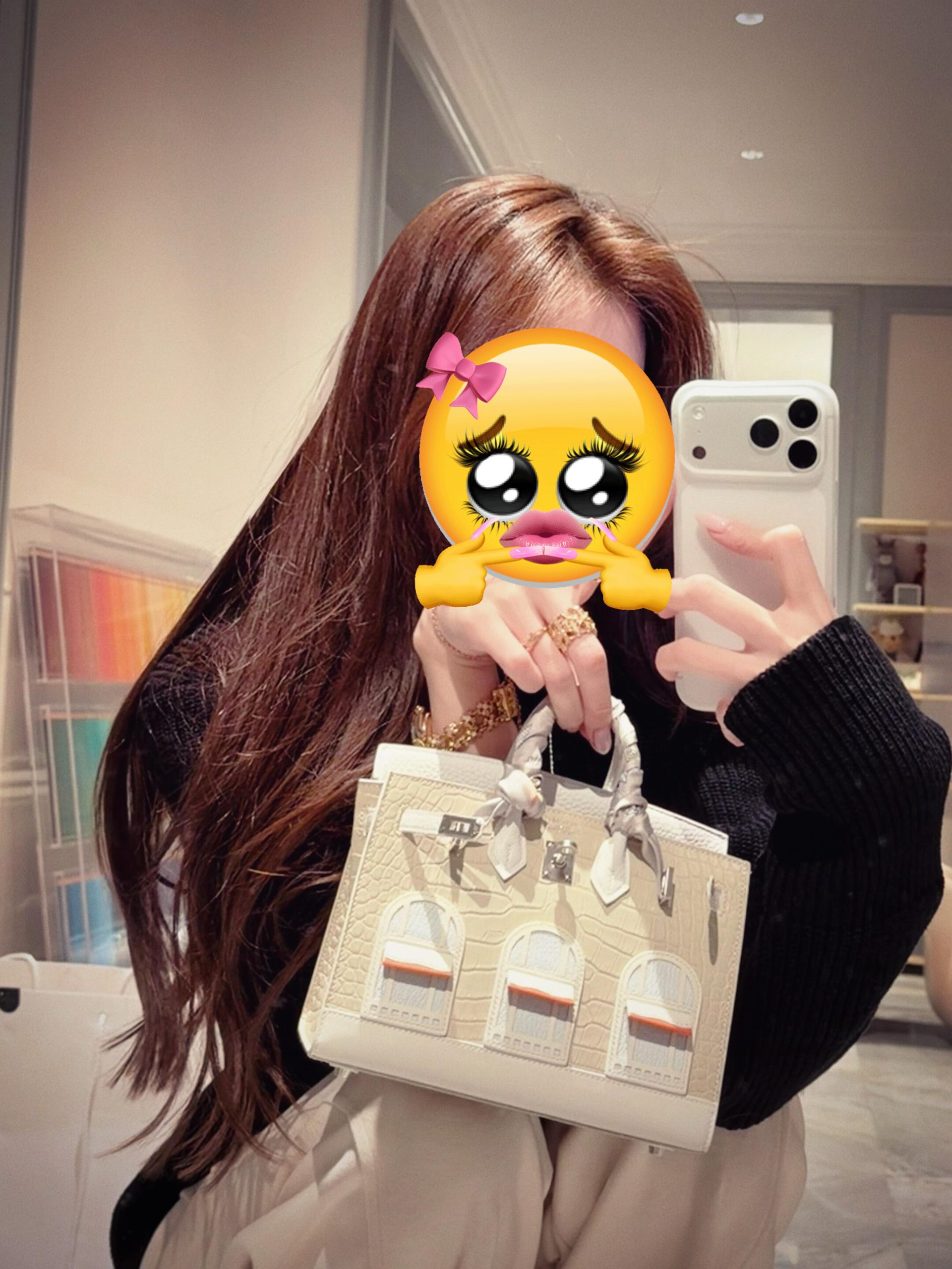 A customer taking a mirror selfie with a Birkin Faubourg white snow house bag.