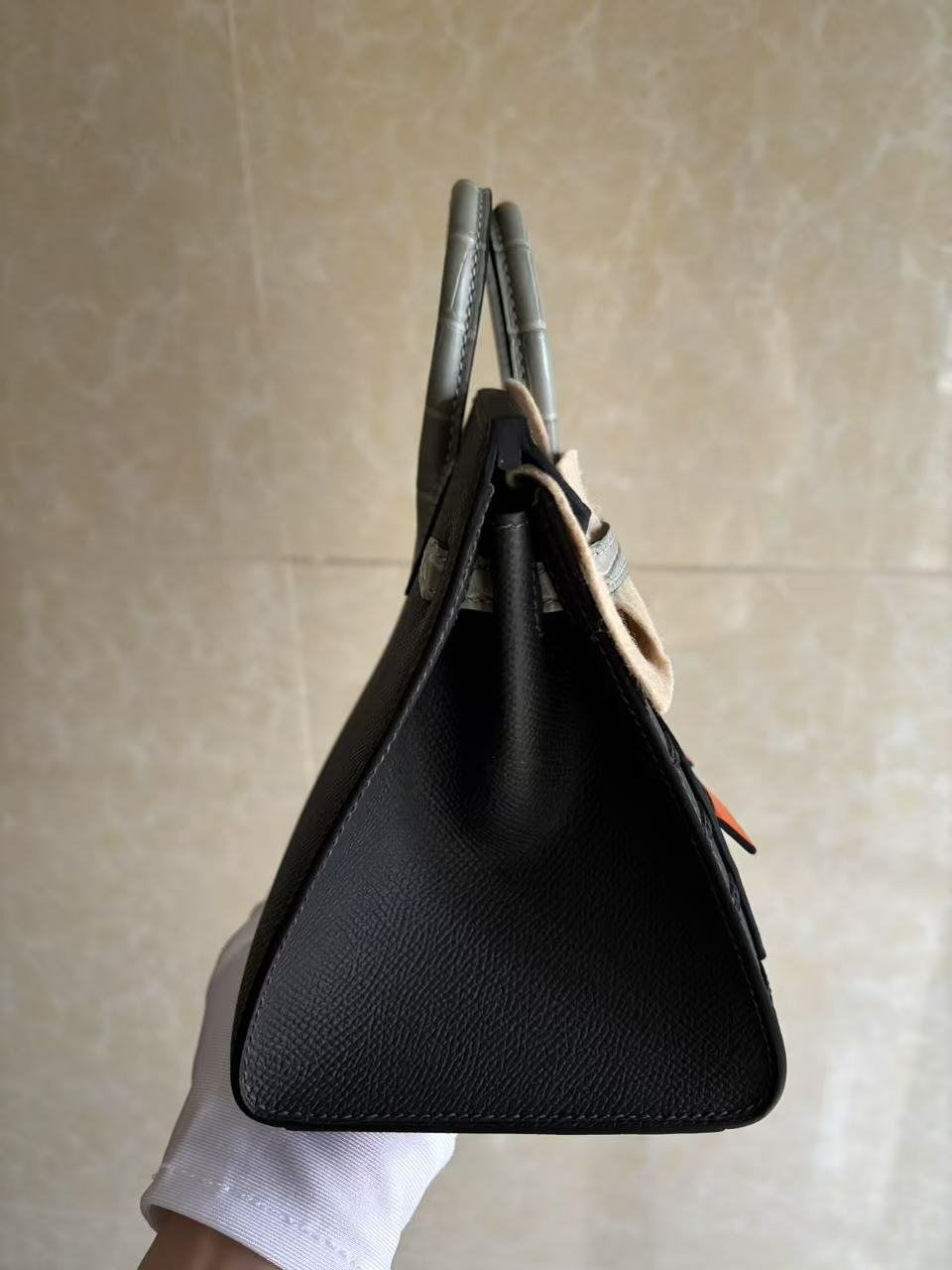 A side profile view of the Birkin Faubourg 20 Rainy Day, emphasizing the crisp 20cm Sellier structured silhouette and the perfect alignment of the leather layers.