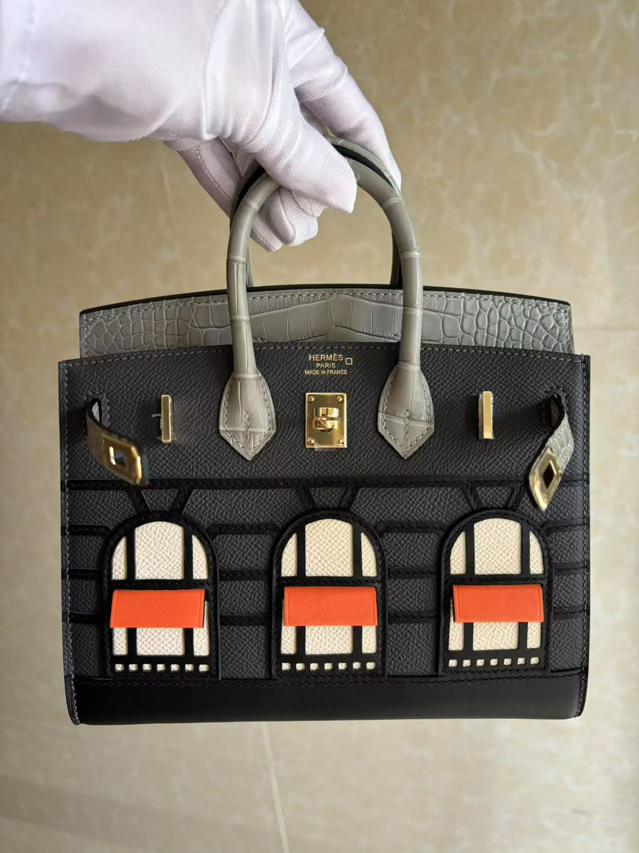 A close-up front view of the Faubourg Birkin 20 Rainy Day in hand
