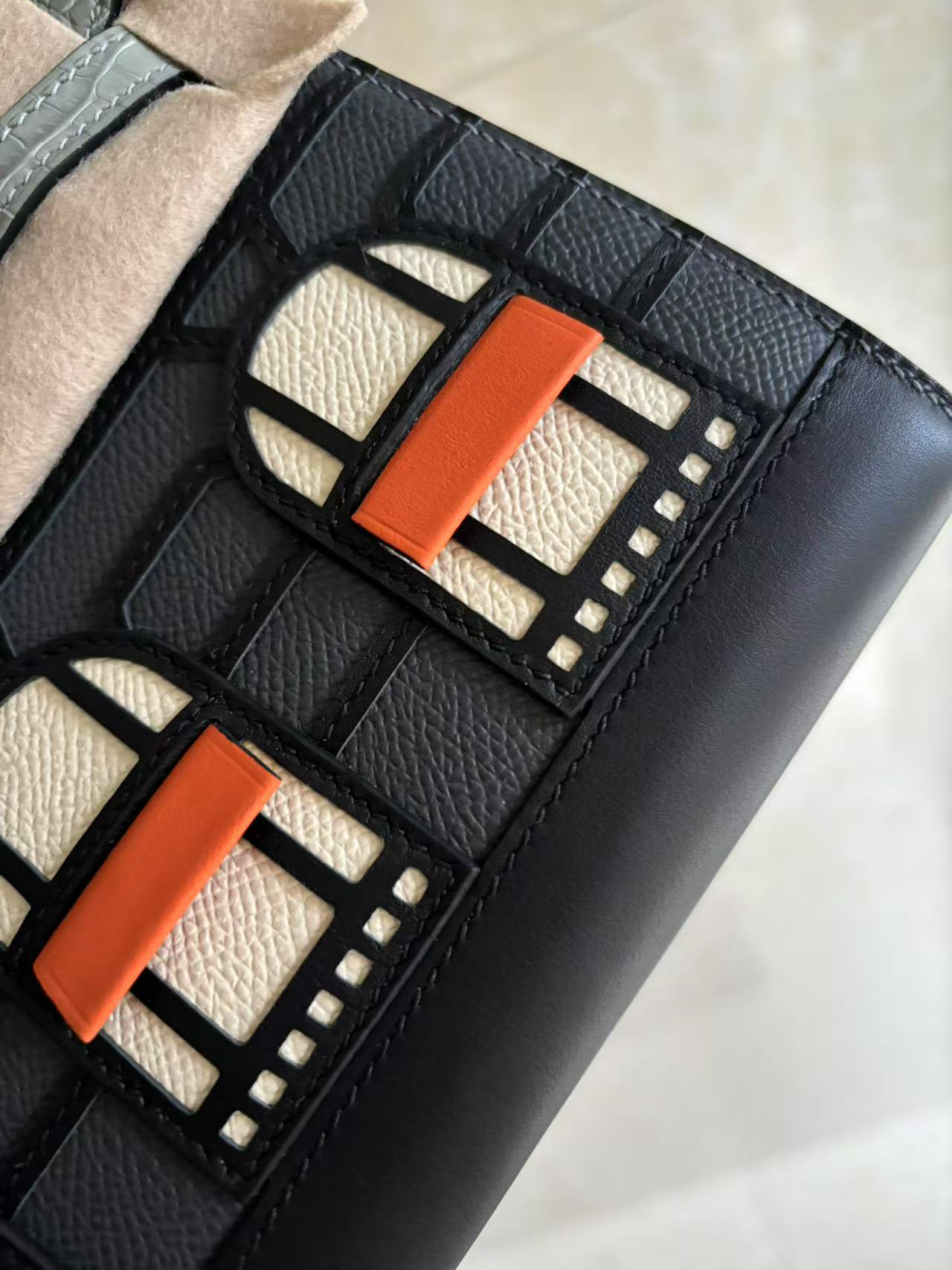 A macro view of the Faubourg Birkin facade, focusing on the surgical precision of the black stitching separating the Epsom leather panels and windows.