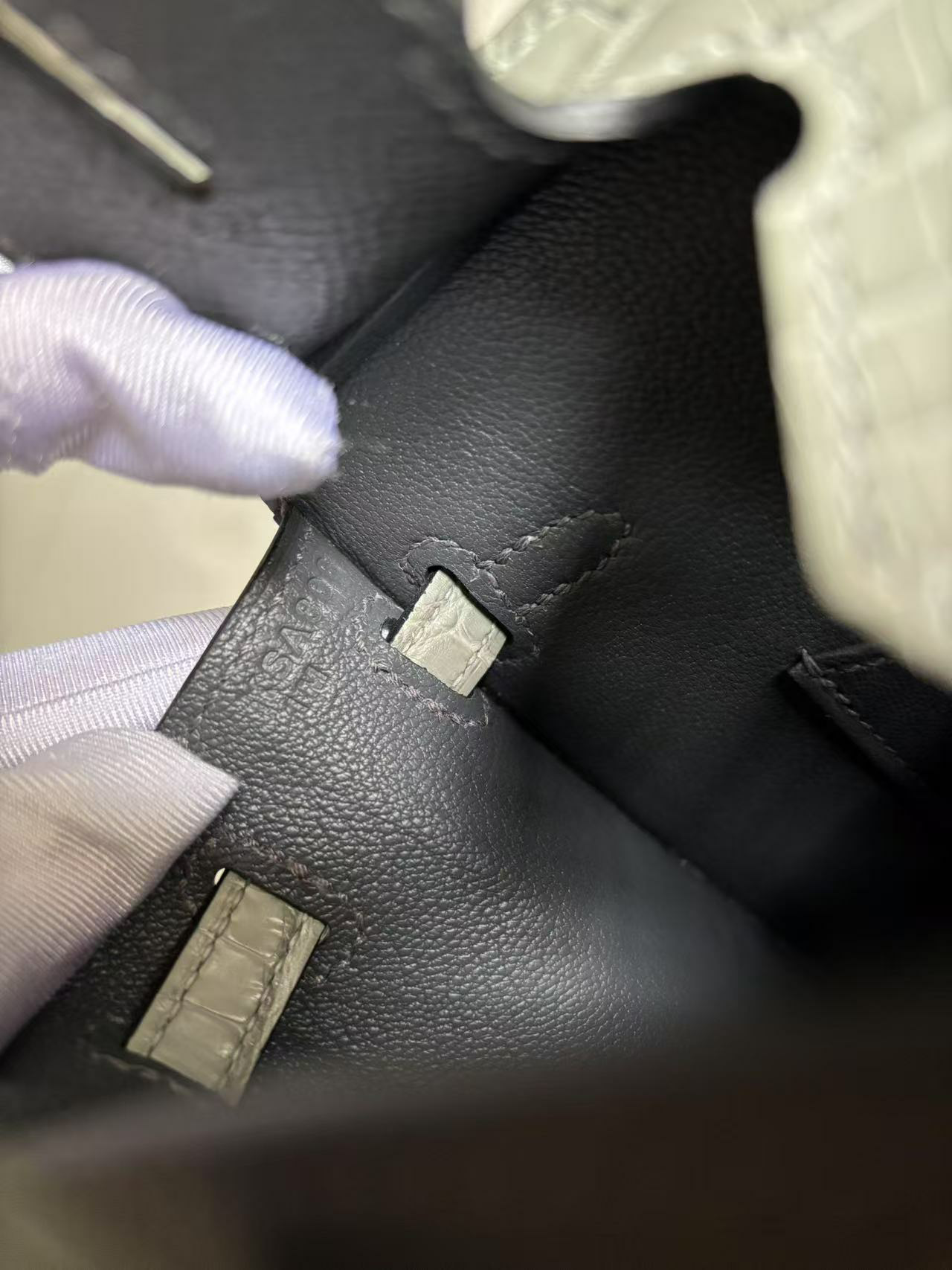 Inside view of the opened Faubourg Birkin 20, detailing the crisp stamps on the internal lining and the smooth finish of the Chèvre leather interior.