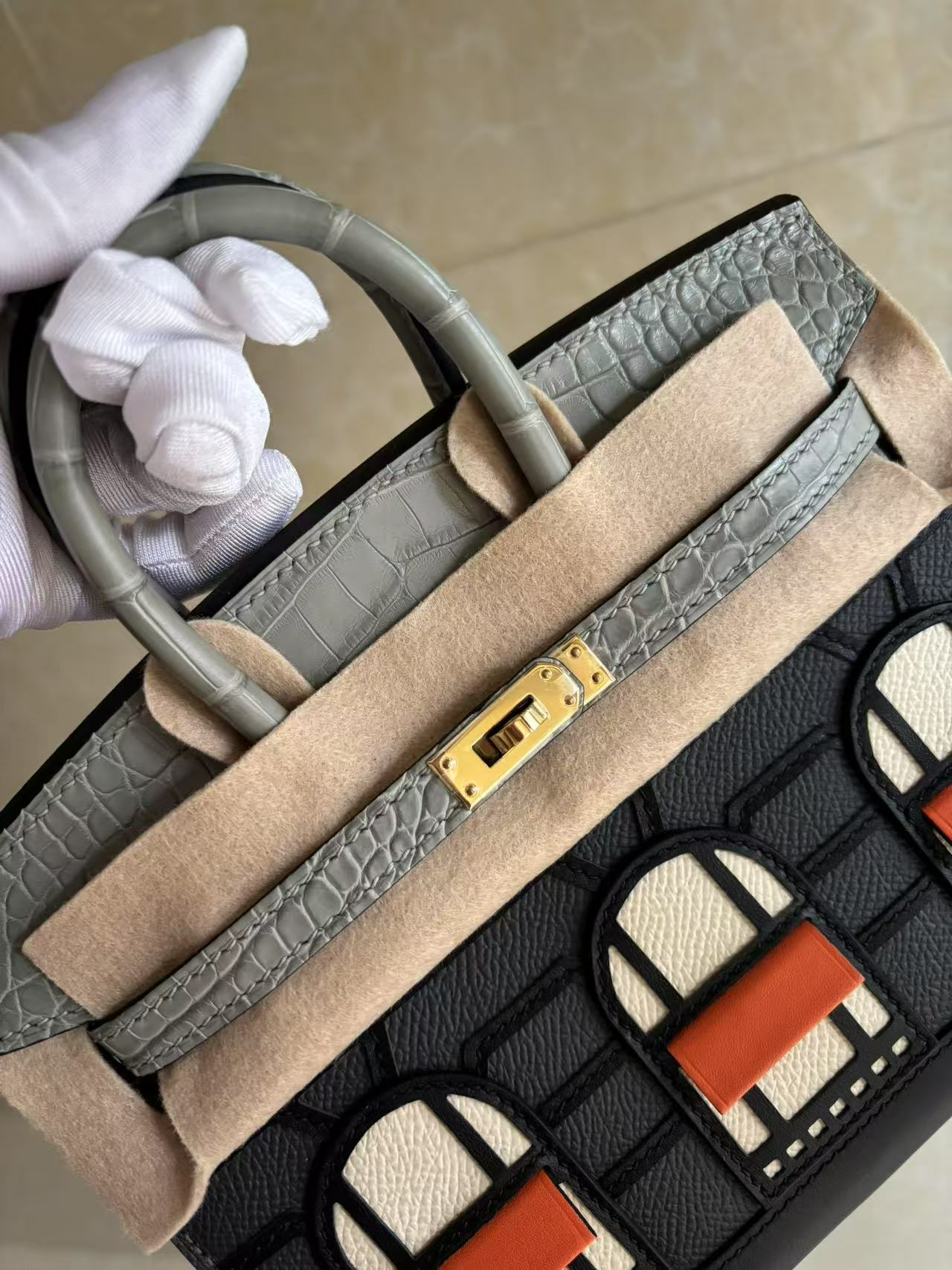 A close-up view of the angled flap and handle of the Faubourg Birkin Rainy Day