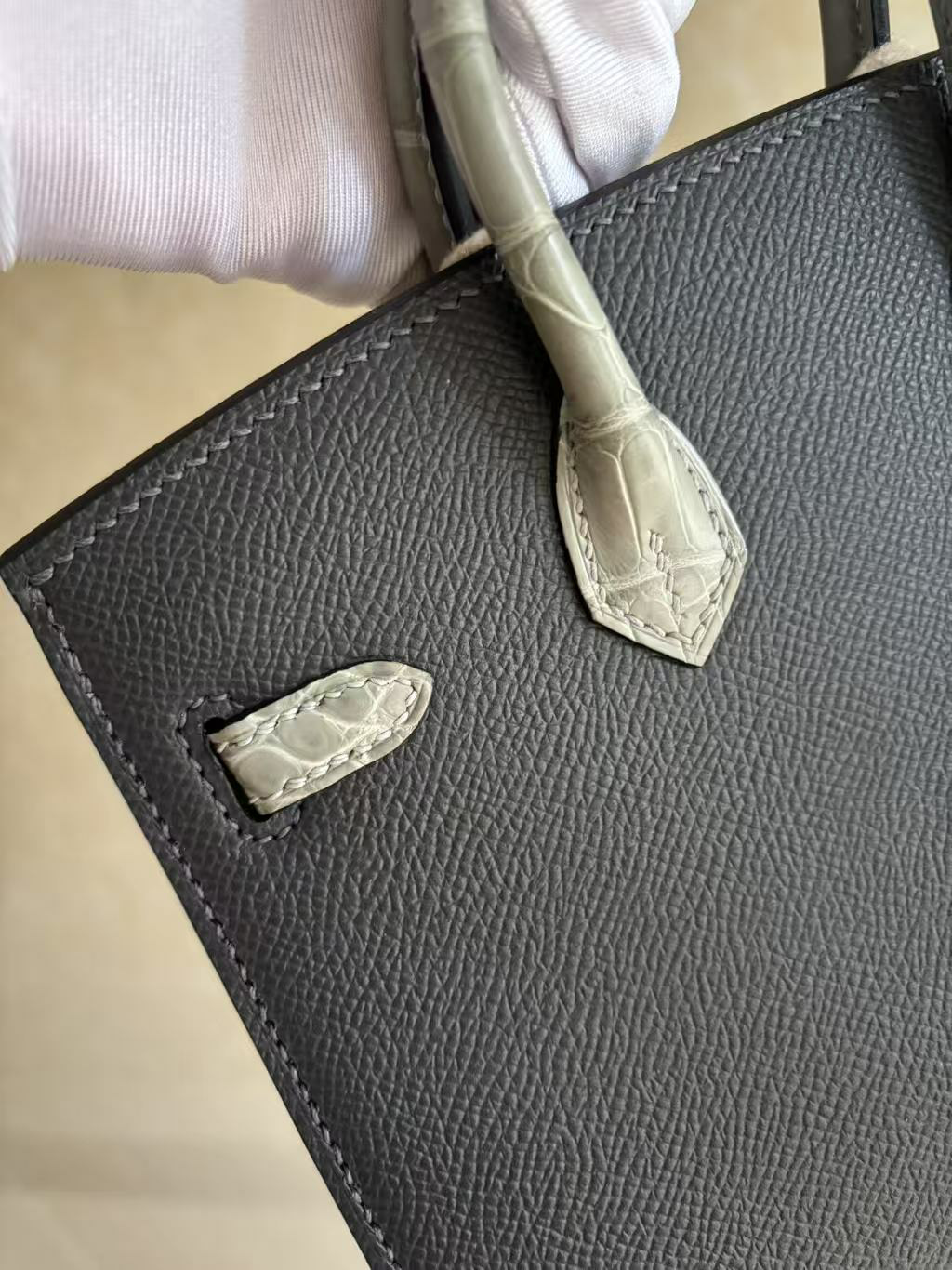 A micro view of the left corner of the Faubourg Birkin 20, emphasizing the sharp Sellier stitching