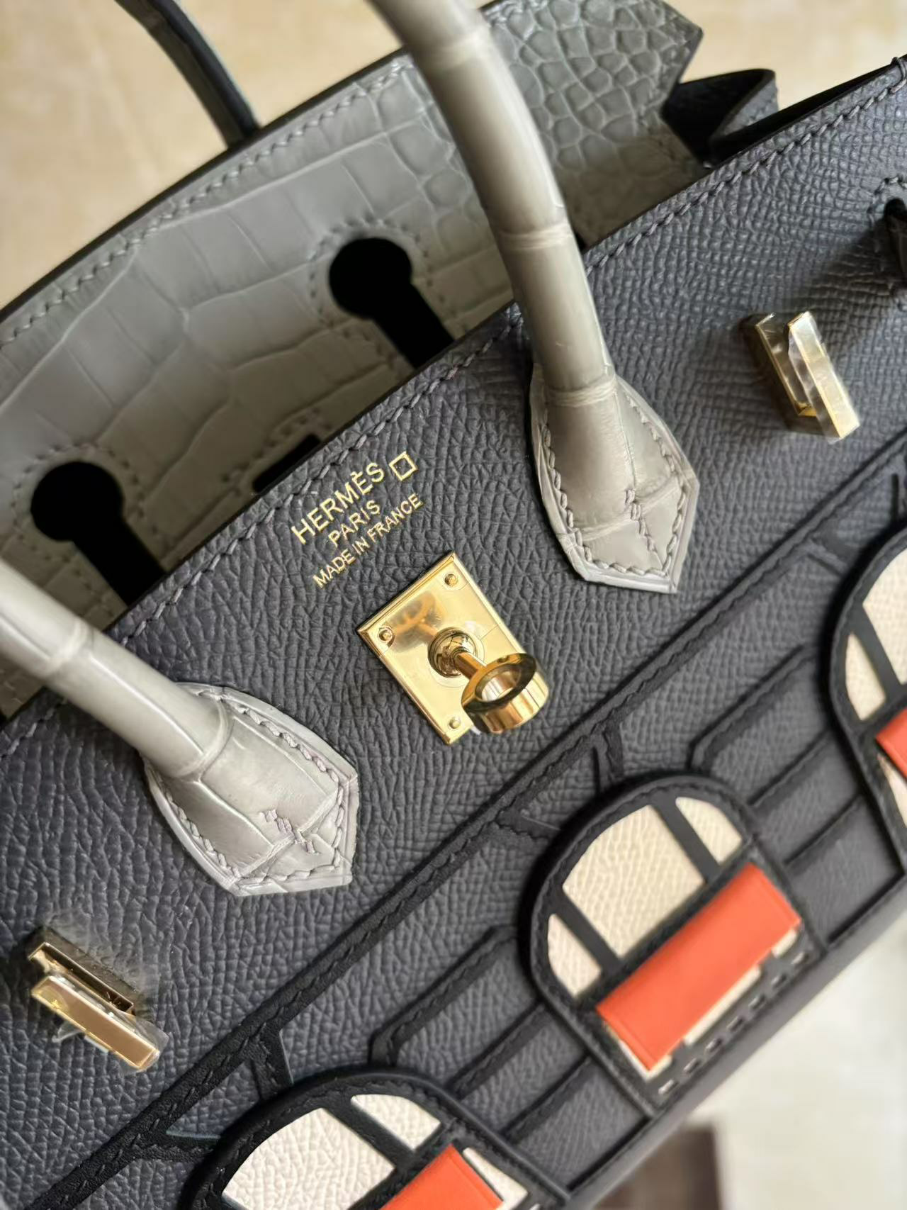 A close-up of the angled sangle hardware of the Faubourg Birkin