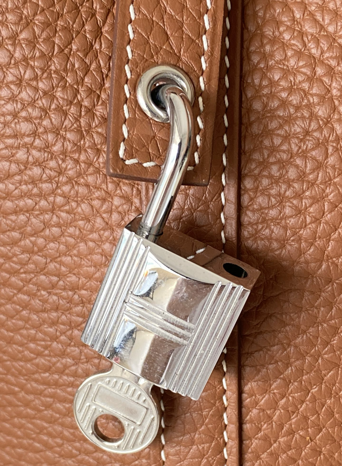 Close-up of the polished Palladium hardware lock and key on a Picotin bag