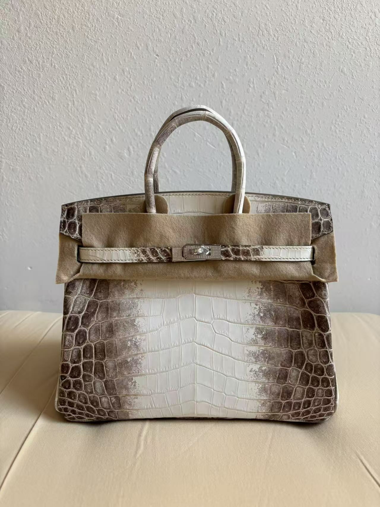 Front view of a Himalayan Birkin 25 (HCP Nile Croc) with custom-set diamond hardware, shown with protective felt for safe delivery.