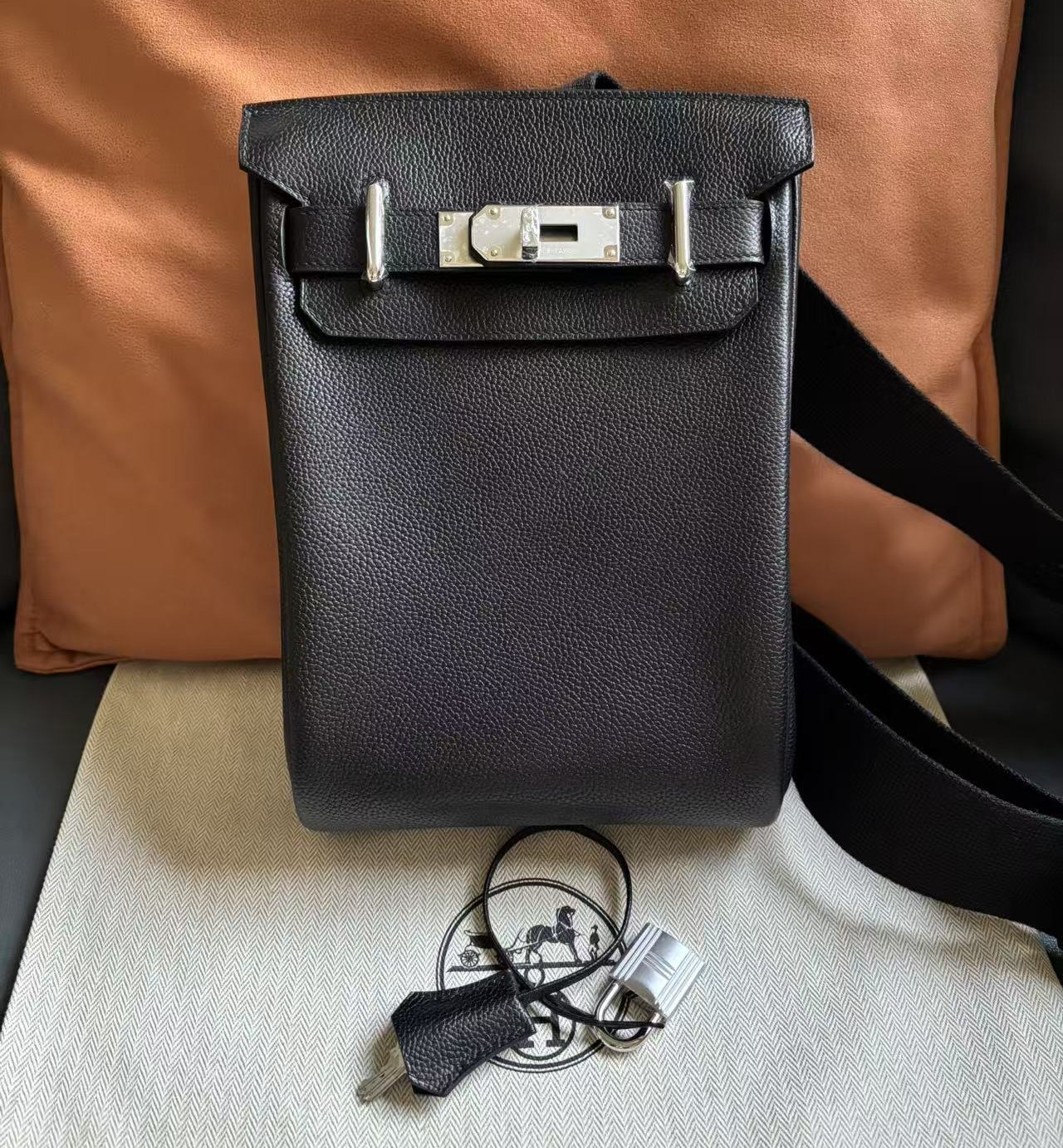 Front view of a custom Hermès HAC a Dos PM backpack in Black Barenia Faubourg leather featuring palladium hardware and a signature toggle closure.