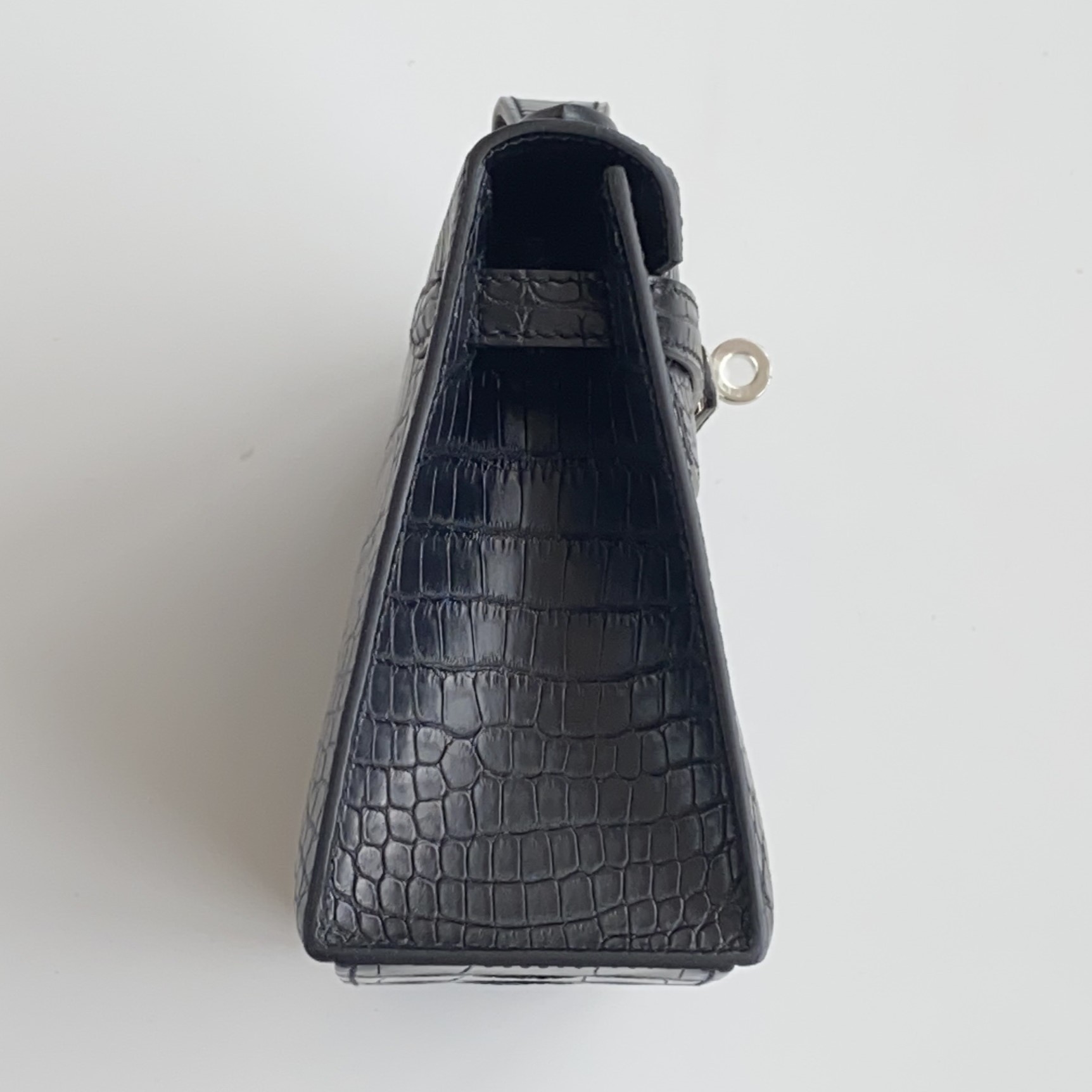 Side profile of the Hermès Kelly clutch Pochette in alligator