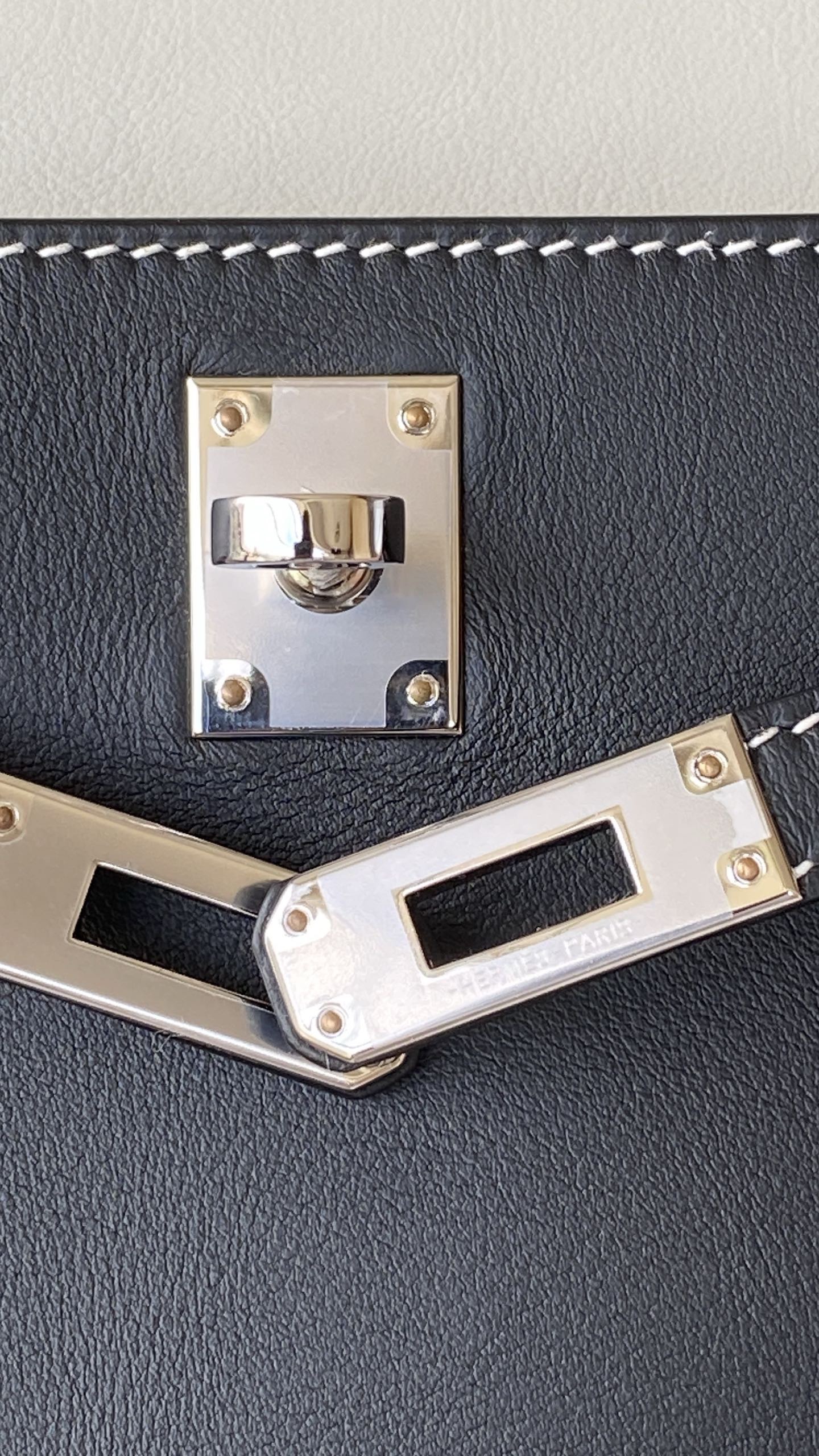 Macro shot of the palladium hardware on the Hermès Kelly Pochette