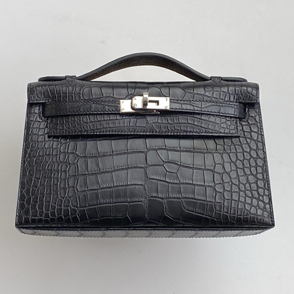 Front view of a Hermès Kelly Pochette in Matte Black Mississippiensis Alligator with perfectly symmetrical scales.