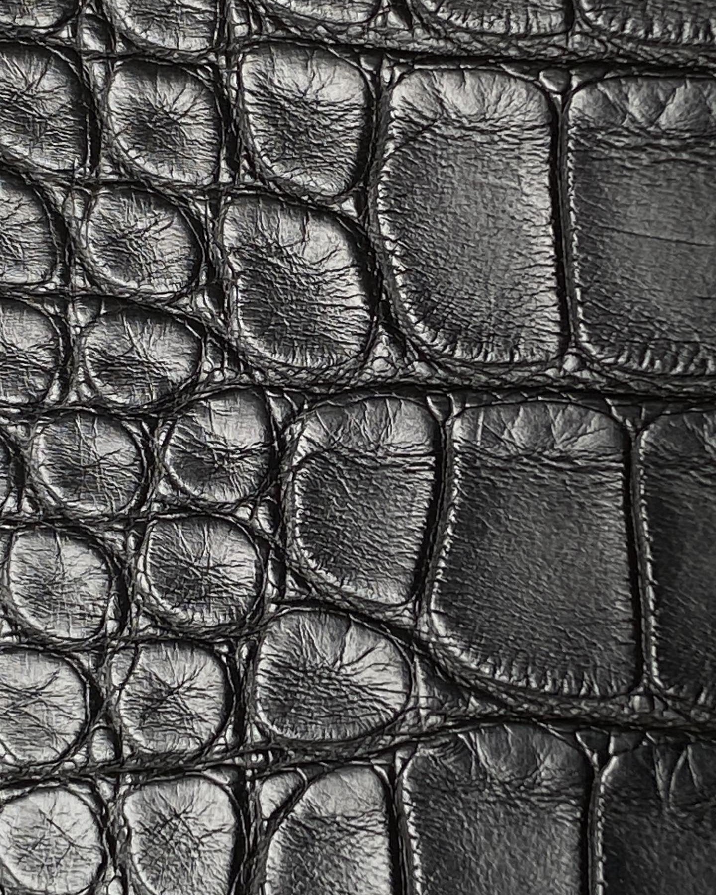 Extreme close-up of the matte alligator skin on a Kelly Pochette Hermès
